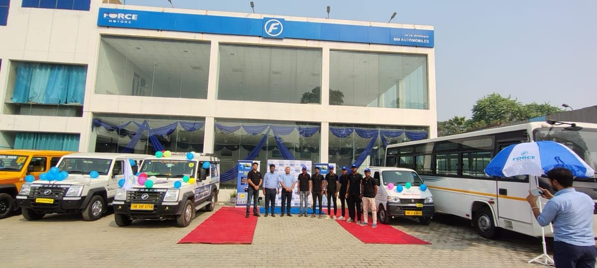 Nukkad natak performers in front of a branded Force Trax vehicle